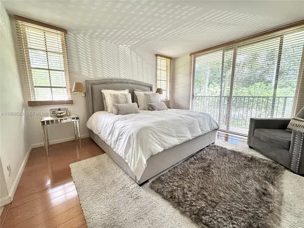 a bedroom with a large bed couch and a large window
