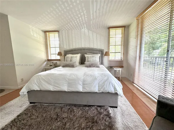 a large bed sitting in a bedroom next to a window