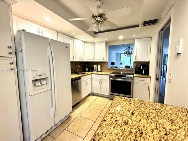 a kitchen with white cabinets and white appliances