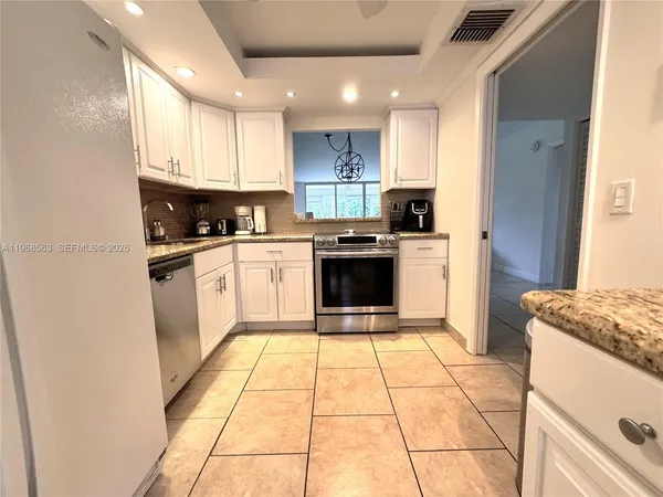 a kitchen with a stove a sink and a refrigerator