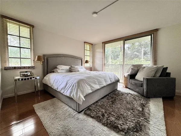 a bedroom with a bed and a couch next to a window