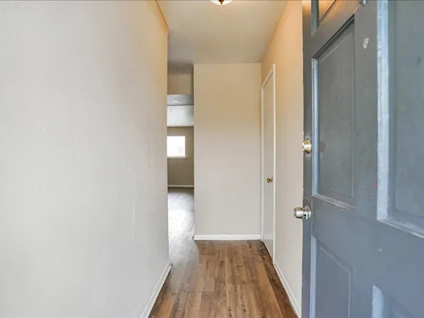 a view of a hallway with wooden floor and closet