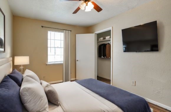 427 Hollyvale Drive, Unit 24 Houston, TX 77060 - Photo 7 of 9 a bedroom with a bed and a flat screen tv