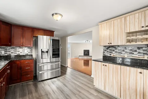 a kitchen with granite countertop wooden cabinets and stainless steel appliances