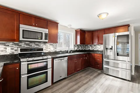 a kitchen with stainless steel appliances kitchen island granite countertop a stove microwave and refrigerator