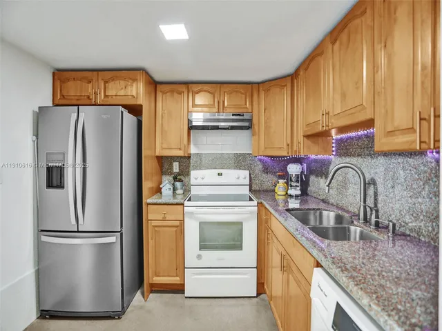 a kitchen with a refrigerator sink and cabinets