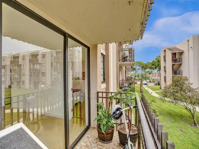 a view of a balcony with a potted plant and brick walls