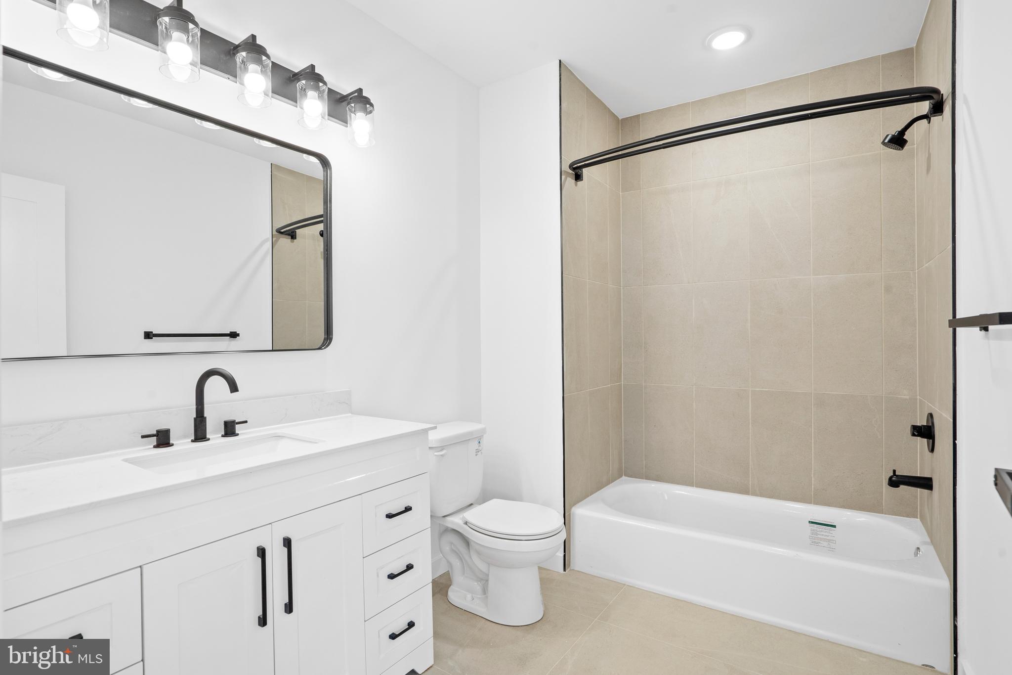 3211 Cedar Street, Unit 402 Philadelphia, PA 19134 - Photo 12 of 21 a bathroom with a double vanity sink and a bathtub