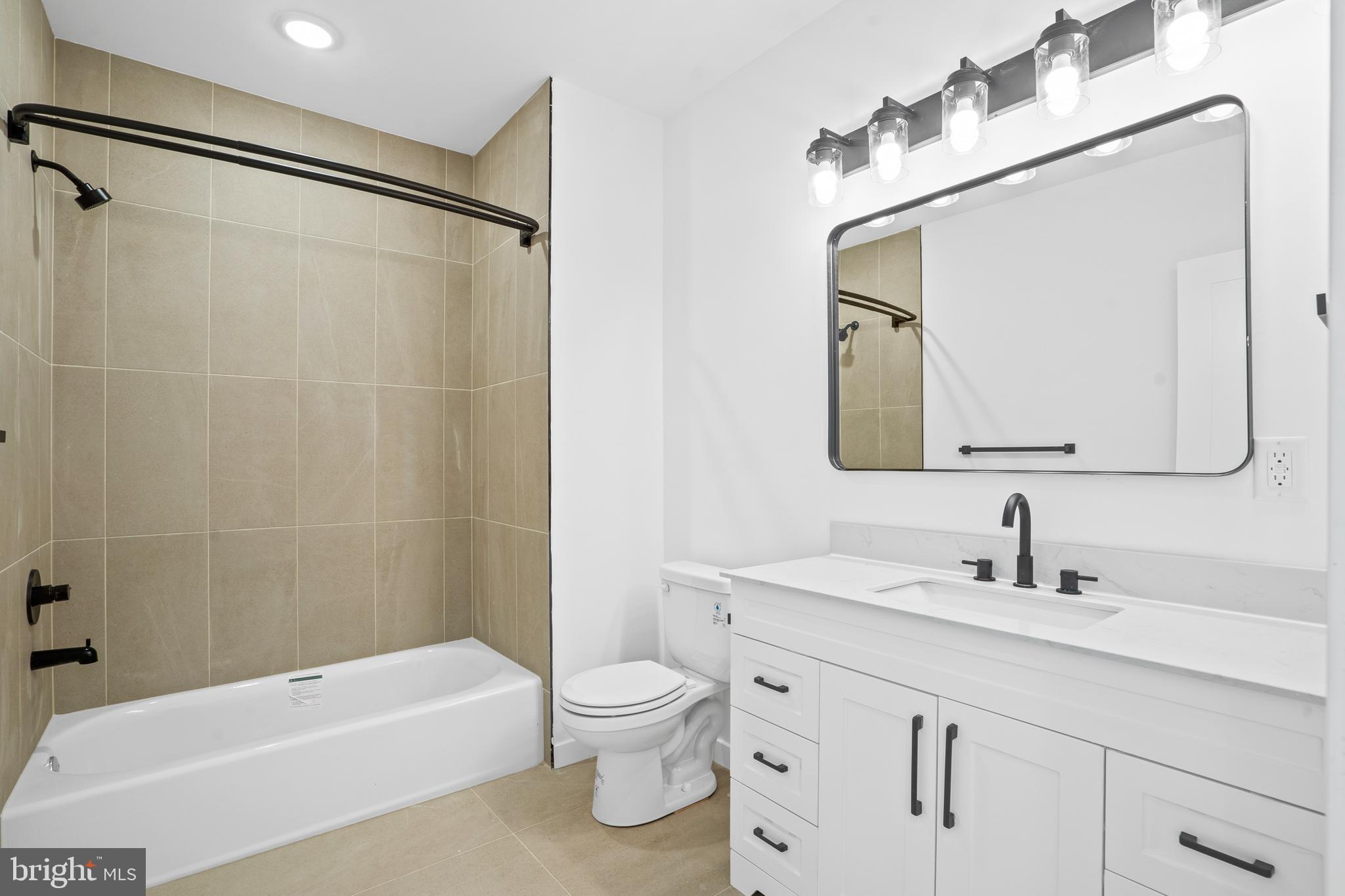 3211 Cedar Street, Unit 402 Philadelphia, PA 19134 - Photo 13 of 21 a bathroom with a bathtub shower sink vanity and toilet
