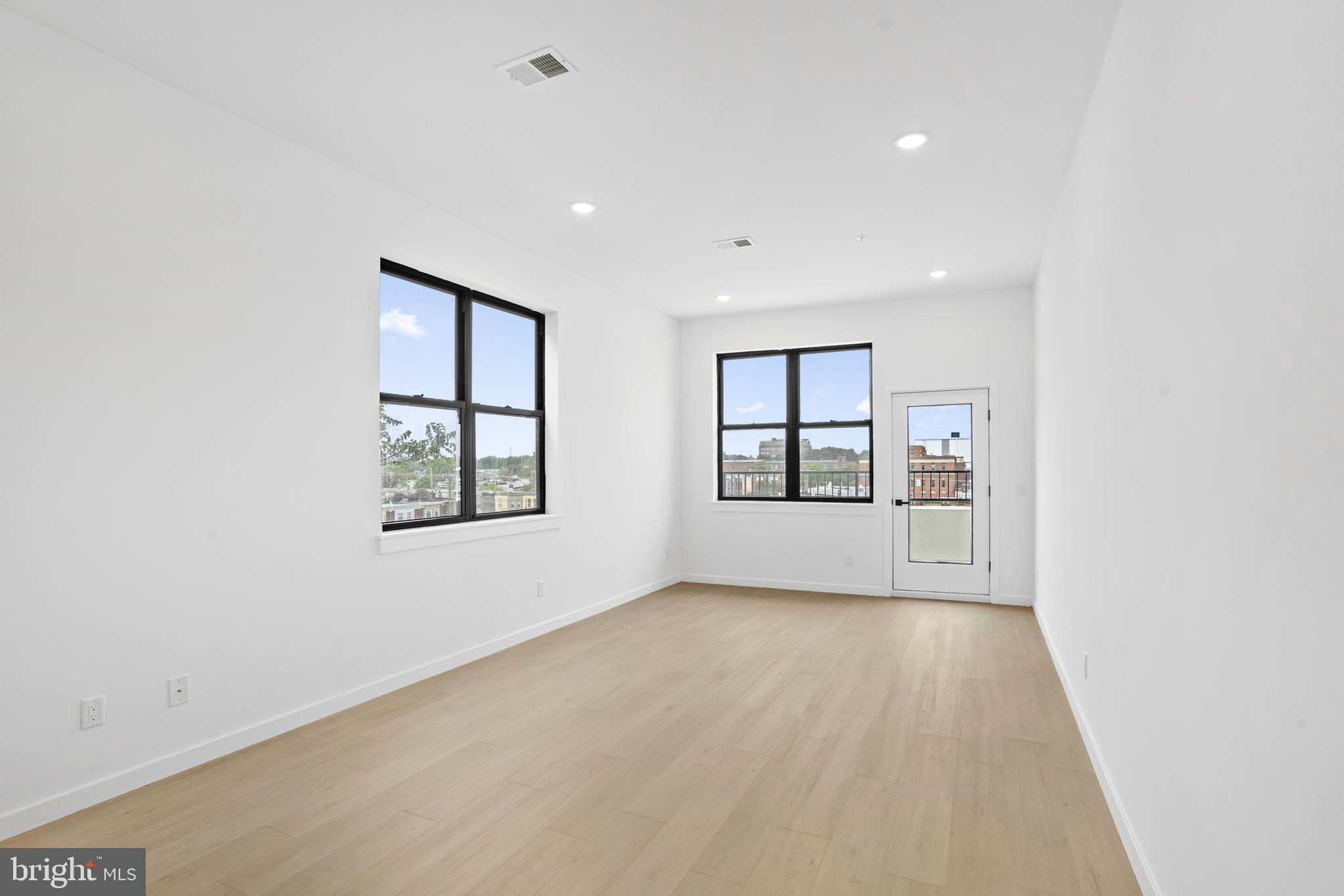 3211 Cedar Street, Unit 402 Philadelphia, PA 19134 - Photo 7 of 21 an empty room with windows and cabinet