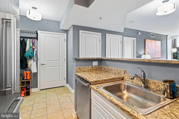 a kitchen with a sink a counter top cabinetry and a refrigerator