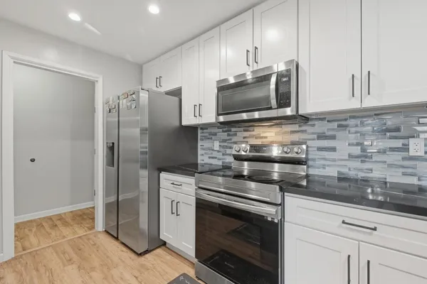 a kitchen with stainless steel appliances wooden cabinets and a stove top oven