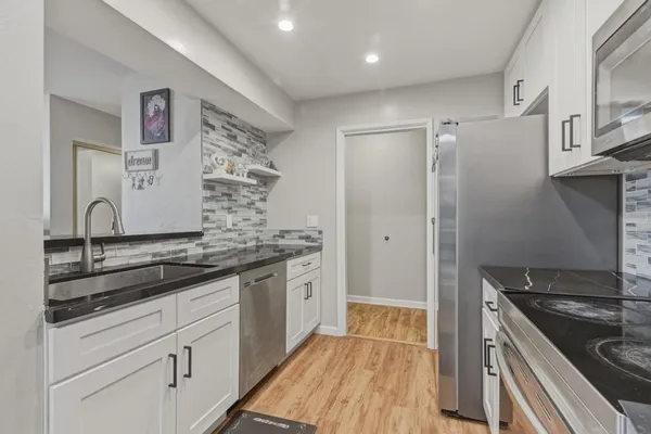 a kitchen with stainless steel appliances granite countertop a stove and a refrigerator