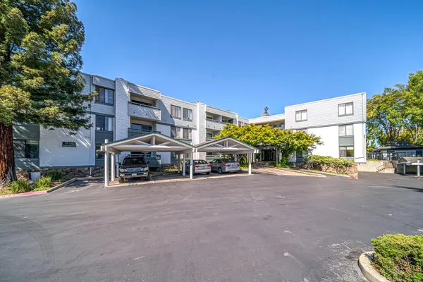 a view of a building with a street and a car parked front of it