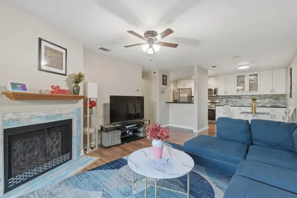 a living room with furniture a fireplace and a flat screen tv