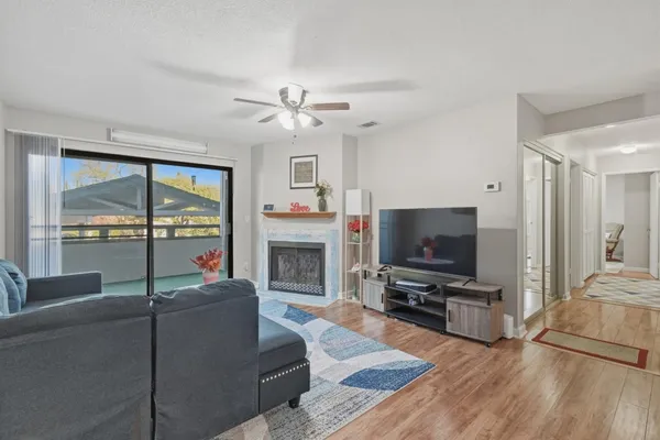 a living room with furniture a flat screen tv and a fireplace