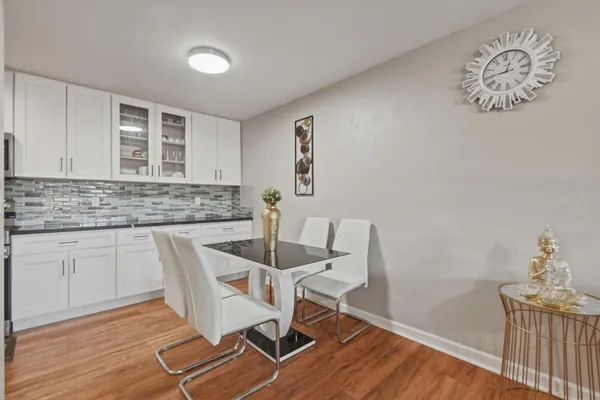 a kitchen with granite countertop a sink cabinets and wooden floor