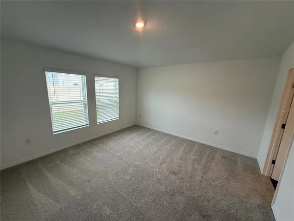 an empty room with windows and closet