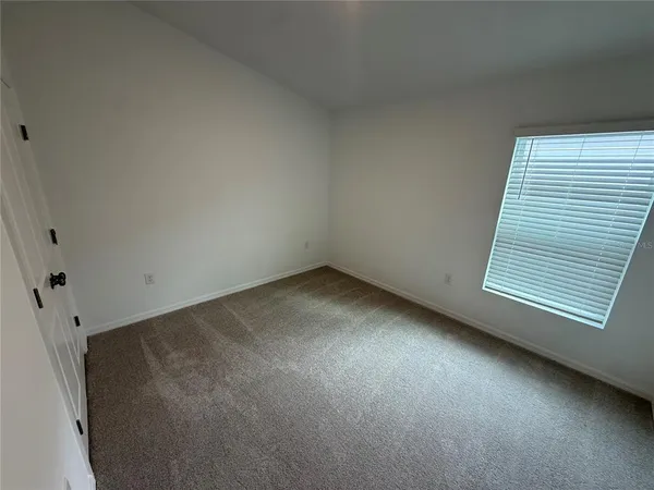 an empty room with a window and doors