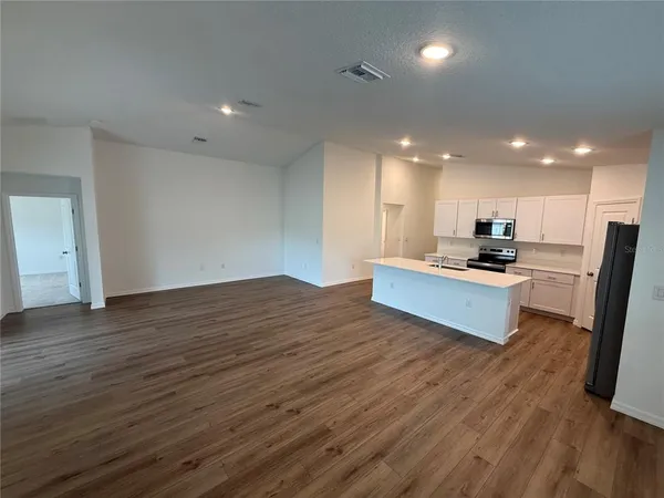 a kitchen with stainless steel appliances kitchen island granite countertop a stove and a refrigerator