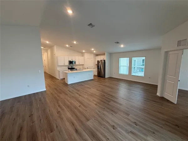 a view of kitchen and hall with wooden floor
