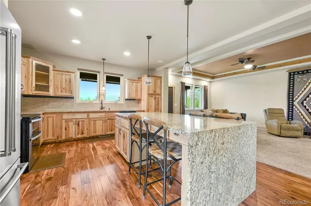 a kitchen with granite countertop a stove a sink and a wooden floors