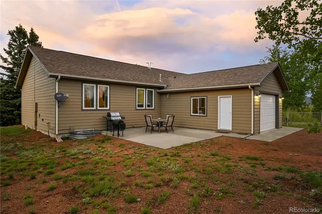 a backyard of a house with table and chairs