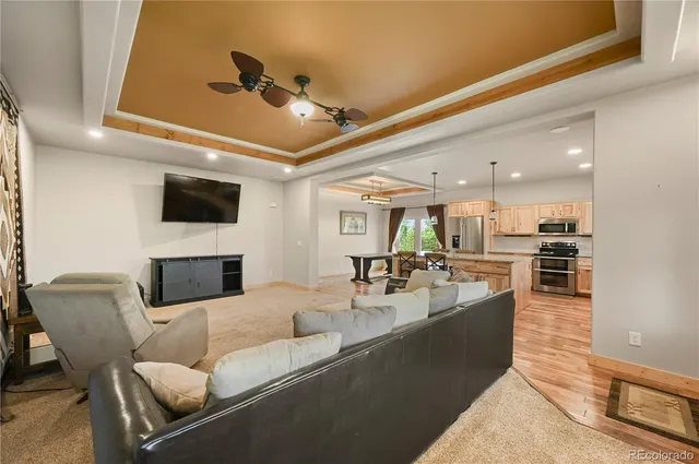 a living room with furniture kitchen view and a flat screen tv