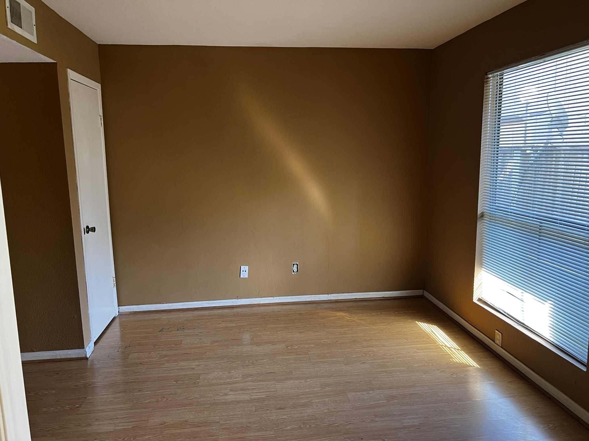 2100 Wilcrest Drive, Unit 114 Houston, TX 77077 - Photo 11 of 13 a view of an empty room with wooden floor and a window