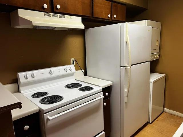 a white refrigerator freezer and a stove sitting inside of a kitchen