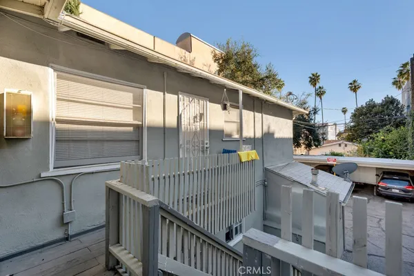 a view of a balcony with wooden floor and fence