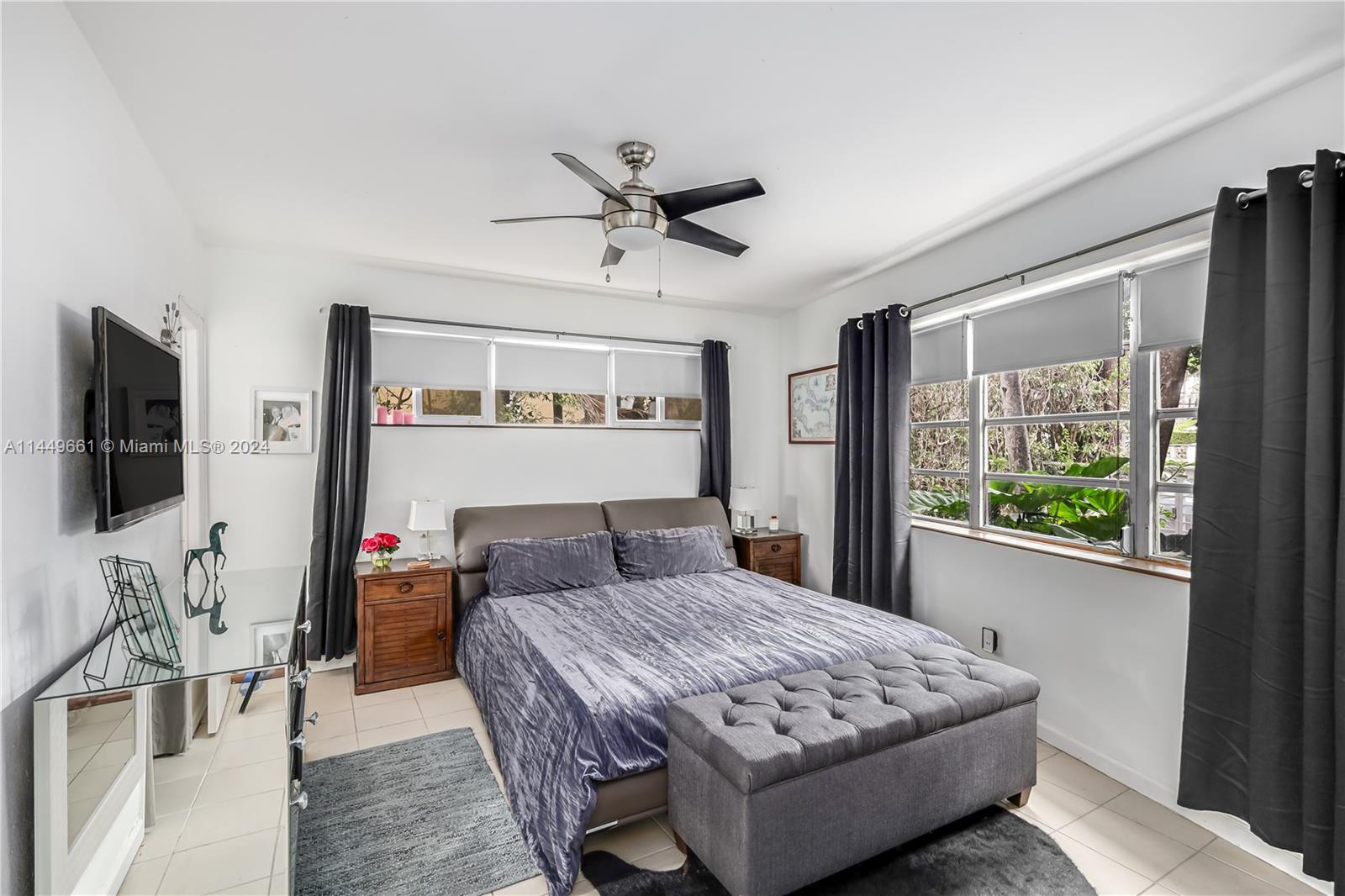 4800 Pine Tree Drive, Unit 101 Miami Beach, FL 33140 - Photo 14 of 30 a bedroom with a bed and a flat screen tv