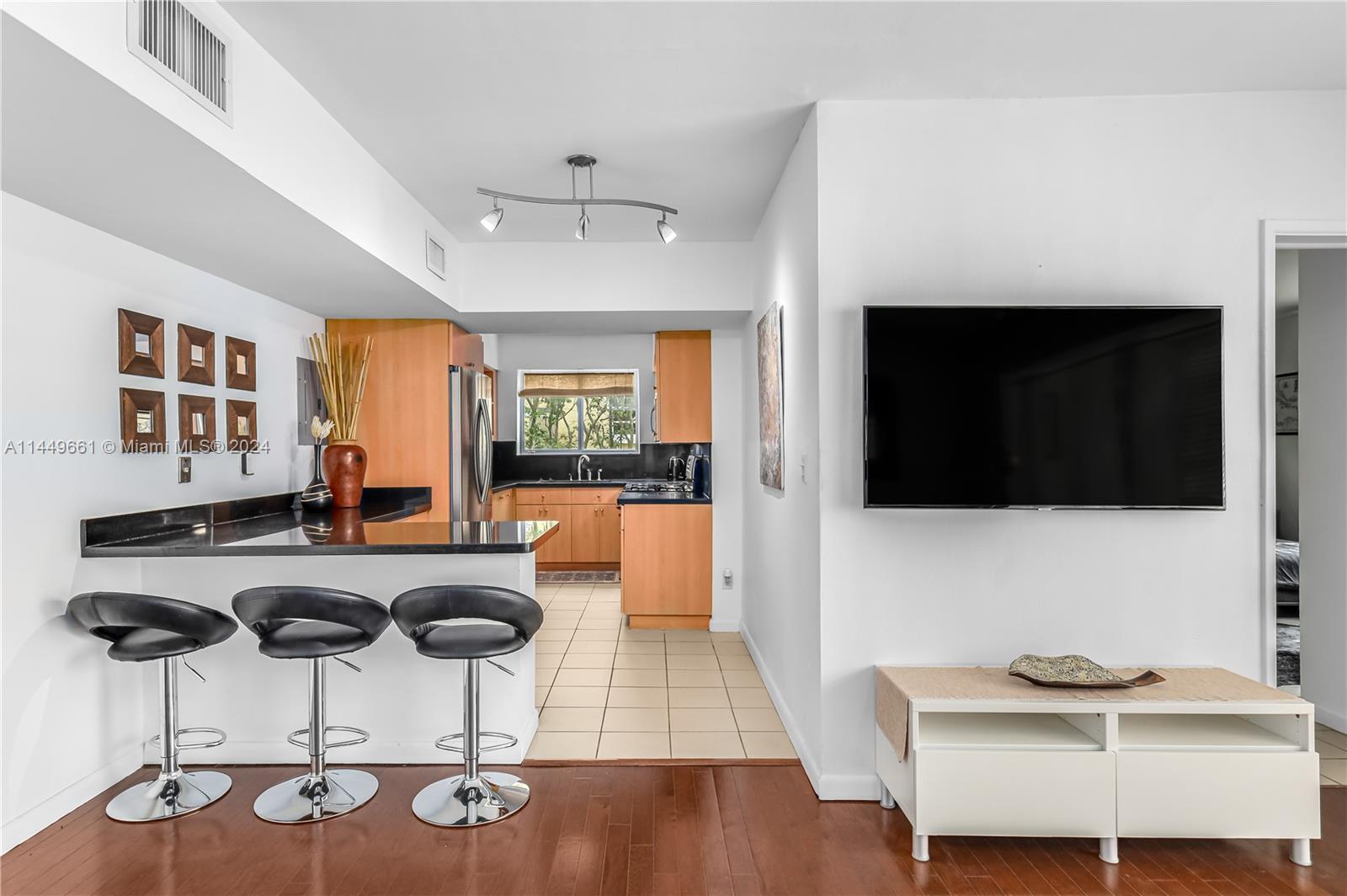 4800 Pine Tree Drive, Unit 101 Miami Beach, FL 33140 - Photo 4 of 30 a living room with furniture and a flat screen tv