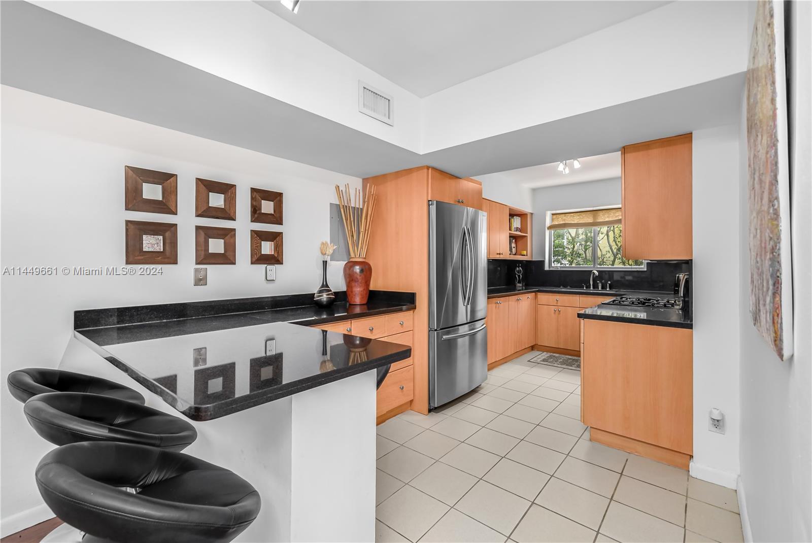 4800 Pine Tree Drive, Unit 101 Miami Beach, FL 33140 - Photo 5 of 30 a kitchen with stainless steel appliances a refrigerator sink and cabinets