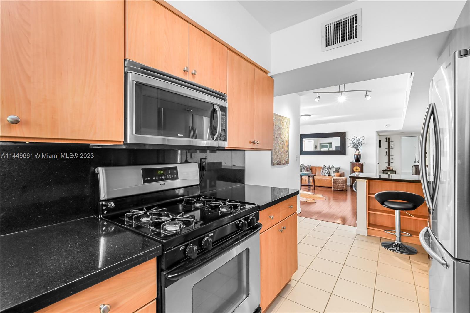 4800 Pine Tree Drive, Unit 101 Miami Beach, FL 33140 - Photo 8 of 30 a kitchen with stainless steel appliances granite countertop a stove and a microwave