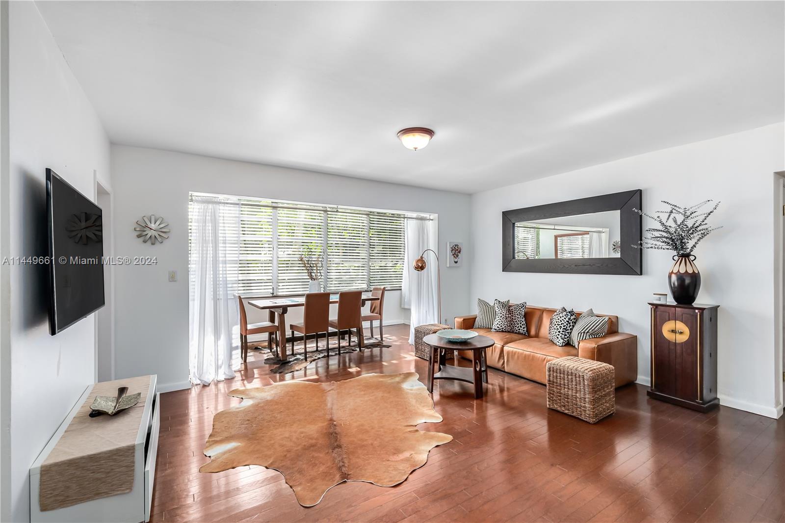 4800 Pine Tree Drive, Unit 101 Miami Beach, FL 33140 - Photo 10 of 30 a living room with furniture and a flat screen tv with wooden floor