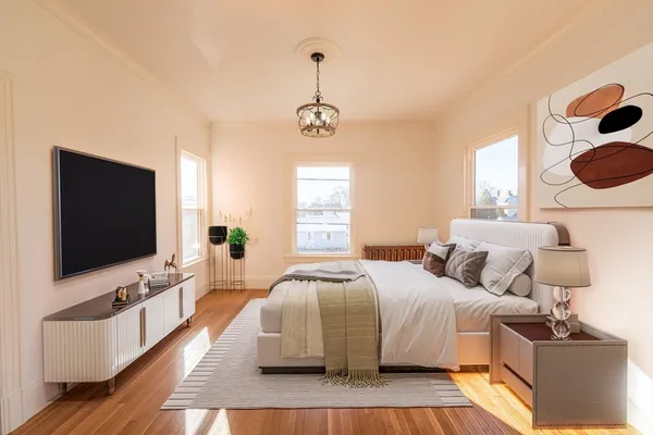 a bedroom with a bed and a flat tv screen on dresser
