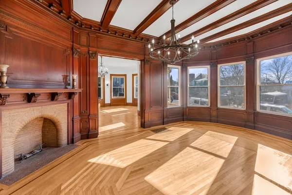 a view of an empty room with a fireplace and a window