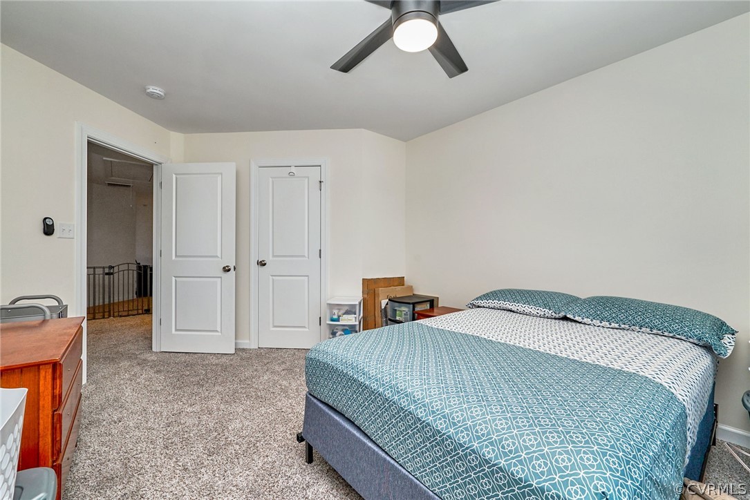 114 Two Penny Place Williamsburg, VA 23185 - Photo 18 of 25 a bedroom with a bed and a chandelier