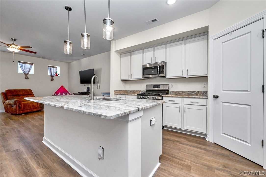 114 Two Penny Place Williamsburg, VA 23185 - Photo 6 of 25 a kitchen with kitchen island granite countertop a stove a sink and a refrigerator
