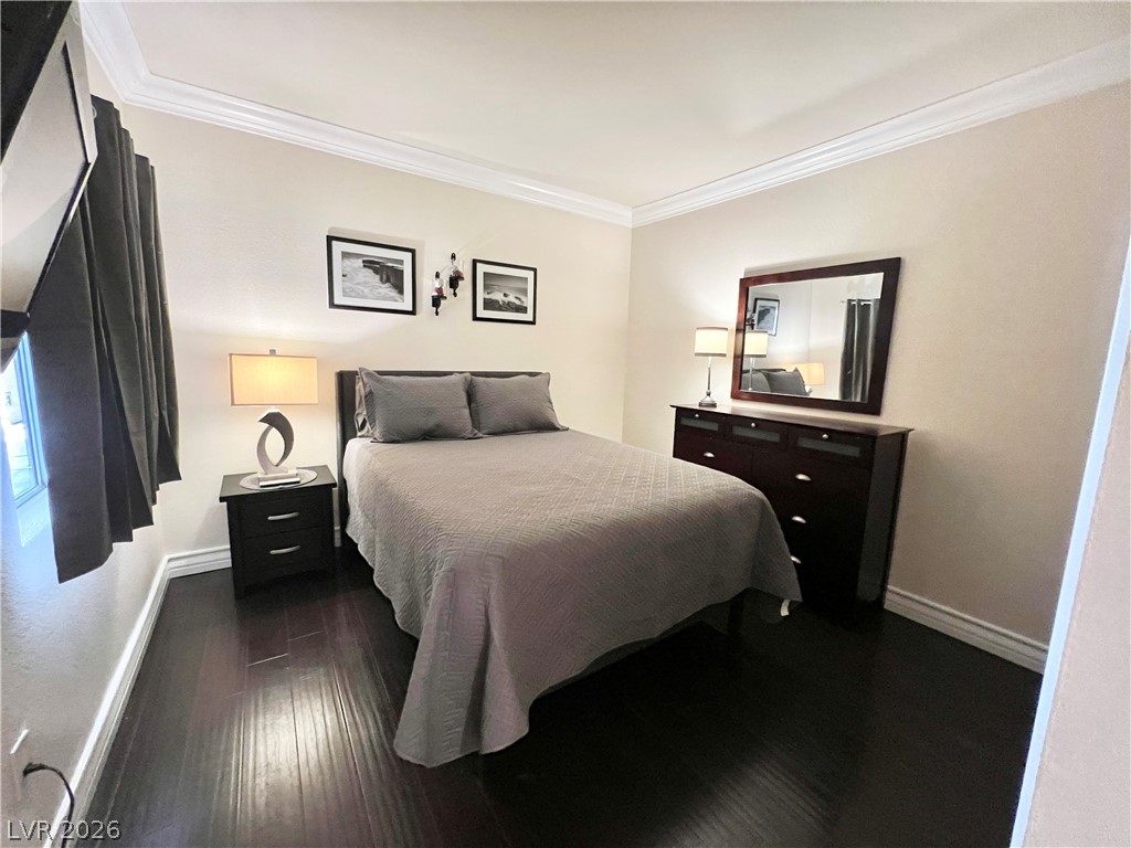 270 East Flamingo Road, Unit 313 Las Vegas, NV 89169 - Photo 15 of 27 Rich hardwood flooring creates a warm and inviting atmosphere in this well-appointed bedroom.