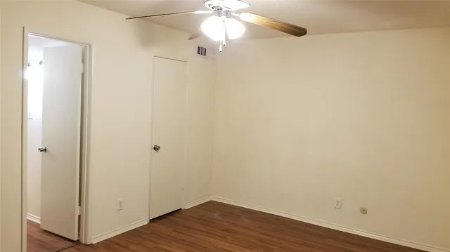 a view of a small space with wooden floor and a ceiling fan