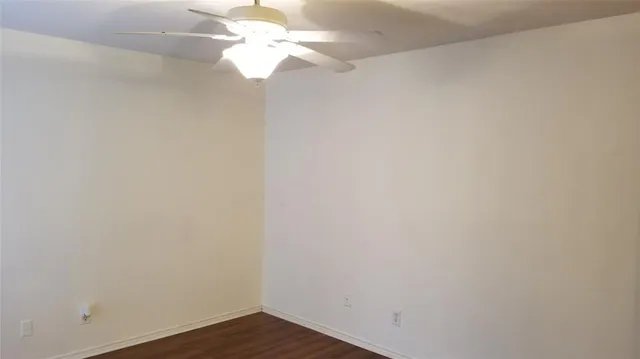 a view of a small space with wooden floor and a ceiling fan