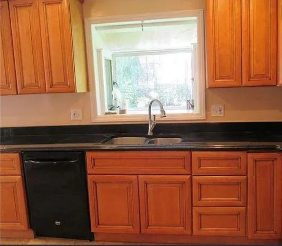 a kitchen with granite countertop cabinets and window
