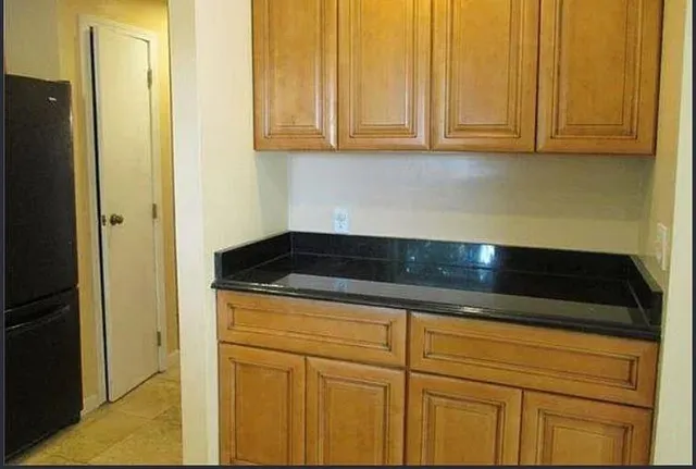 a kitchen with granite countertop white cabinets and a sink