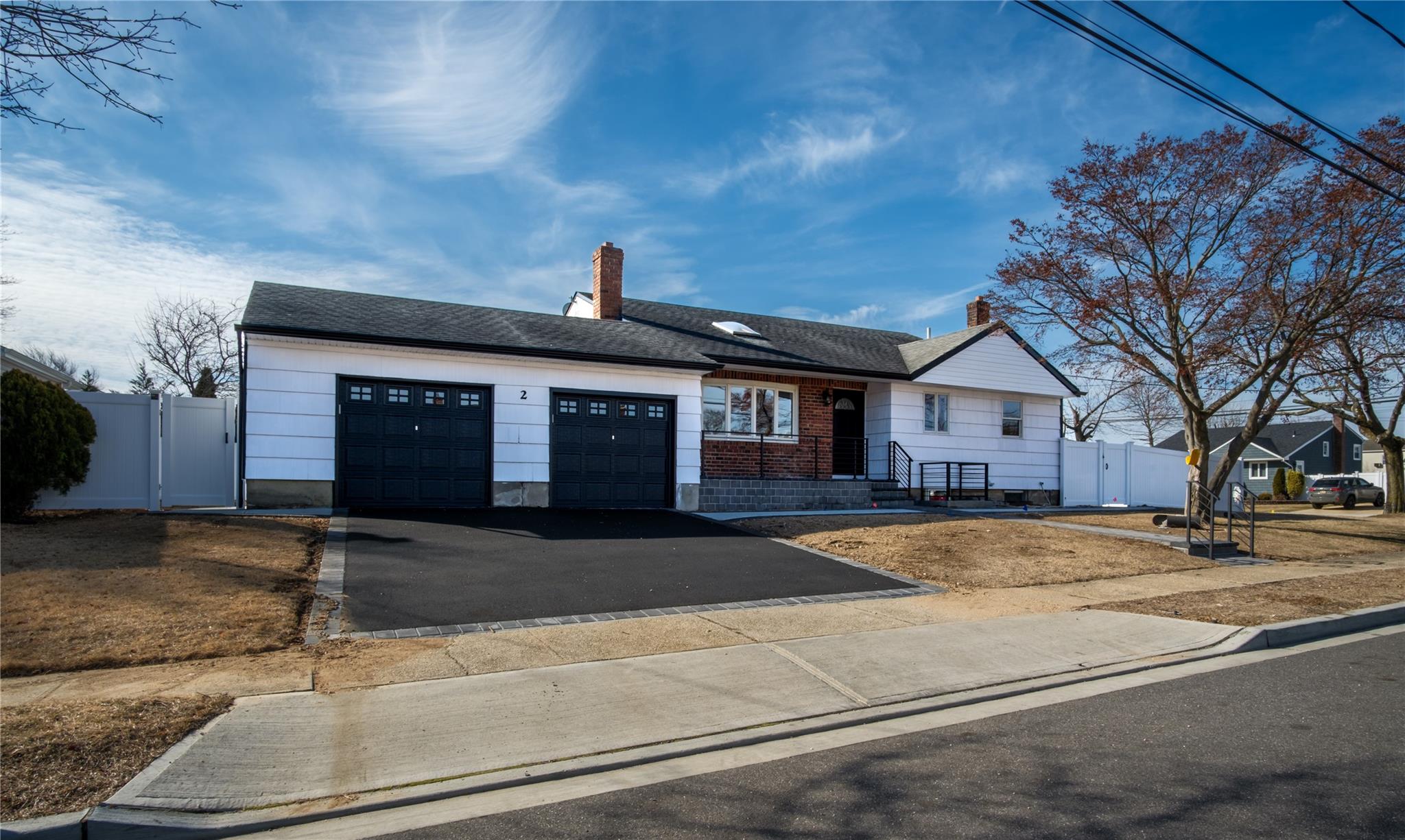 Ranch-style house with an attached garage, a gate, fence, and aphalt driveway