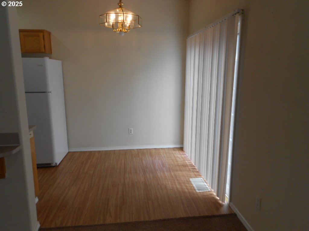 18440 Southwest Johnson Street Beaverton, OR 97003 - Photo 3 of 10 en empty room with wooden floor and fan