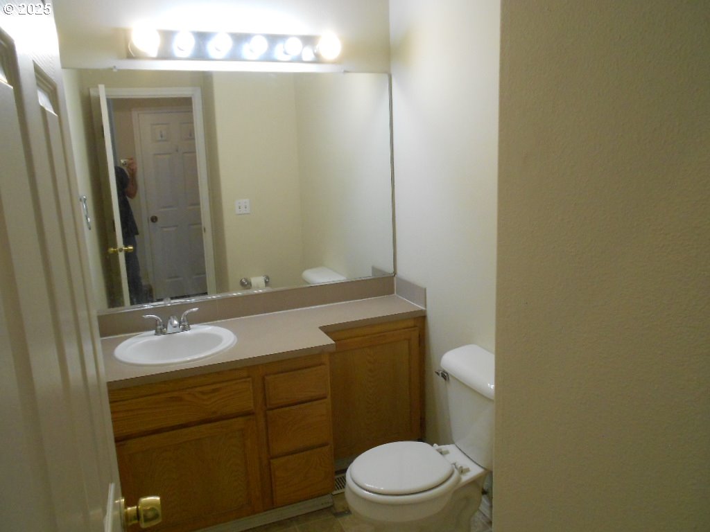 18440 Southwest Johnson Street Beaverton, OR 97003 - Photo 9 of 10 a bathroom with a granite countertop sink toilet and mirror