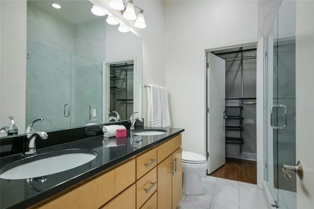 a bathroom with a granite countertop sink a toilet and a mirror