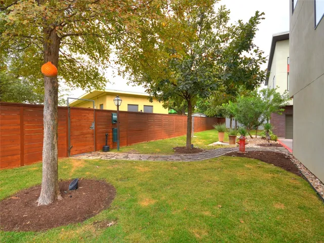 a view of a backyard with table and chairs and a large tree